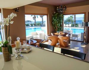 a living room with a mirror and a swimming pool at Valis Resort Hotel in Volos