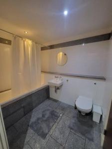 a bathroom with a toilet and a sink at Striking 1 bedroom apartment in Manchester
