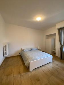 Schlafzimmer mit einem weißen Bett und Holzboden in der Unterkunft Canelli 3 in Turin