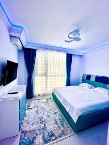 a blue bedroom with a bed and a tv at Marcony Summerland Apartments in Mamaia