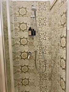 y baño con ducha y pared de azulejos. en Cuore d’Orlando apartment, en Capo dʼOrlando