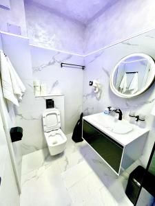 a white bathroom with a sink and a toilet at Marcony Summerland Apartments in Mamaia