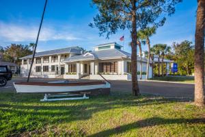 a boat on the grass in front of a house at Paddletail Waterfront Lodge in Crystal River