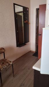 een kamer met een spiegel en een houten vloer bij Готель Деметра in Charkov