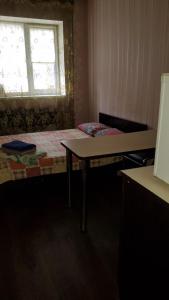 een slaapkamer met een bed, een tafel en een raam bij Готель Деметра in Charkov