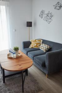 a living room with a blue couch and a table at Appartement adorable et jardin in Villiers-sur-Marne