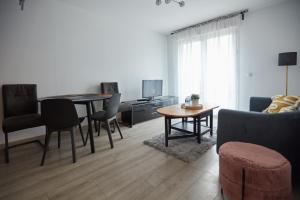 a living room with a table and chairs and a couch at Appartement adorable et jardin in Villiers-sur-Marne