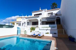 a villa with a swimming pool in front of a house at Villa a Sul in Albufeira