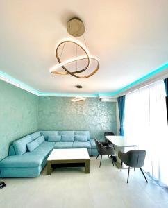 uma sala de estar com um sofá azul e uma mesa em Marcony Summerland Apartments em Mamaia