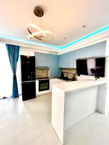 uma cozinha com um balcão branco e um tecto em Marcony Summerland Apartments em Mamaia