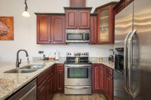 a kitchen with wooden cabinets and stainless steel appliances at Luxury Downtown Rental - La Dolce Vita Villa #3 in Moab