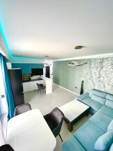 a living room with a blue couch and a table at Marcony Summerland Apartments in Mamaia