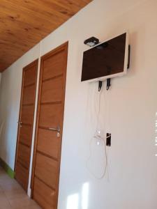 a room with a tv on the wall and a door at Cabañas Rowal in Potrerillos