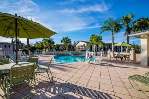 a patio with a table and chairs and a pool at PaddleTail Waterfront Lodge, Trademark Collection by Wyndham in Crystal River +22 photos