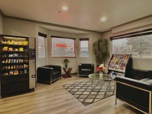 - un salon avec une table, des chaises et un réfrigérateur dans l'établissement City Creek Inn & Suites, à Salt Lake City