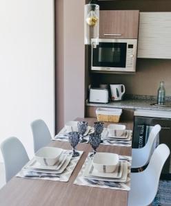 - une cuisine avec une table, des chaises et un four micro-ondes dans l'établissement Dunas costa concon, à Concón