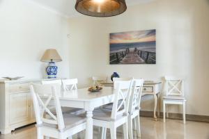 una sala da pranzo con tavolo e sedie bianchi di Villa a Sul ad Albufeira