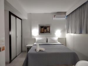 un dormitorio con una cama con un animal de peluche en Hotel Oscar Gold Savassi en Belo Horizonte