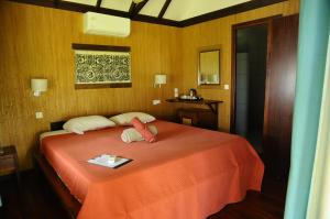 a bedroom with a bed with two towels on it at Raira Lagon in Avatoru