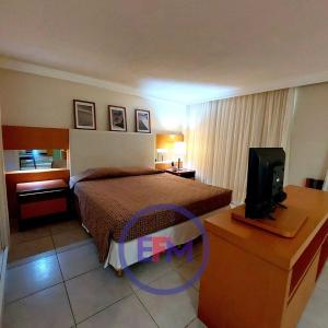a hotel room with a bed and a television at Varandas - Apartamentos in Natal