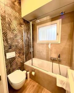 uma casa de banho com um WC, uma banheira e uma janela. em Home Donatella em Cormano
