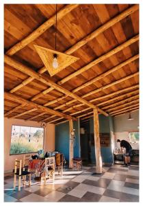 a living room with wooden ceilings and tables and chairs at Cabaña San Roque in Humahuaca