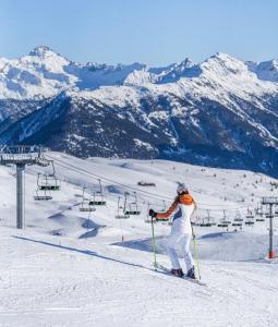 a woman on skis in the snow on a ski lift at Le Mélèze in Villar-Saint-Pancrace