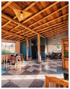 a living room with wooden ceilings and a checkered floor at Cabaña San Roque in Humahuaca