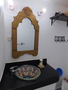 a bathroom with a sink and a mirror on a counter at Dar Gabriel in Chefchaouene