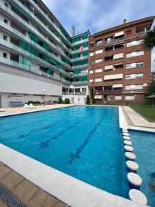 a large swimming pool in front of a building at Ático en Lloret de Mar in Lloret de Mar
