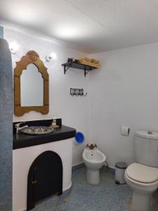a bathroom with a toilet and a sink and a mirror at Dar Gabriel in Chefchaouene