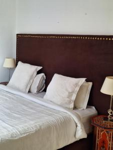 a bedroom with a bed with white sheets and pillows at Dar Gabriel in Chefchaouene