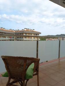 een stoel op een balkon met een witte muur bij Ático en Lloret de Mar in Lloret de Mar