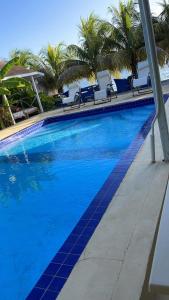 une grande piscine bleue avec des chaises et des palmiers dans l'établissement Point Bay Resort, à Calliaqua