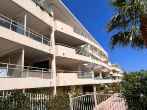 een appartementencomplex met een balkon en een palmboom bij Proche Monaco luxueux appartement vue mer in Cap d'Ail