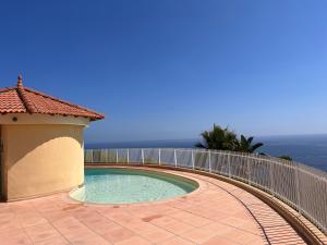 een zwembad met een hek op een patio bij Proche Monaco luxueux appartement vue mer in Cap d'Ail