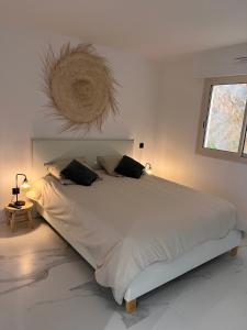 een slaapkamer met een groot wit bed met 2 kussens bij Proche Monaco luxueux appartement vue mer in Cap d'Ail