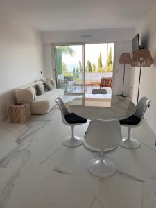 een woonkamer met een tafel en stoelen en een bank bij Proche Monaco luxueux appartement vue mer in Cap d'Ail