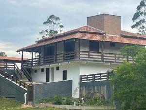 ein großes Haus mit einer Veranda und einem Balkon in der Unterkunft SÍTIO CANTINHO DO SOSSEGO, Casa de campo, pescaria, lareira, jogos de bilhar, area gourmet etc in Treze de Maio