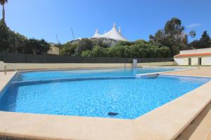 duży basen z niebieską wodą w obiekcie Appartement avec piscine - Albufeira w Albufeirze