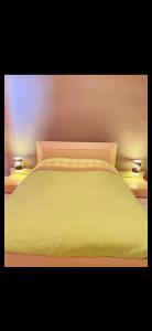 een wit bed met twee lichten erop bij Belle appartement chaleureux à 2 mn à pied du tramway. in Saint-Étienne