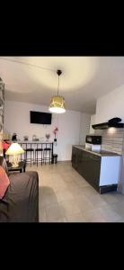 een woonkamer met een keuken en een eetkamer bij Belle appartement chaleureux à 2 mn à pied du tramway. in Saint-Étienne