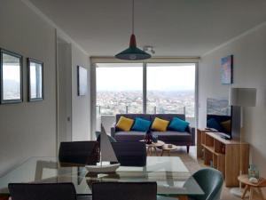 sala de estar con sofá y mesa de cristal en Departamento playa La Herradura, en Coquimbo