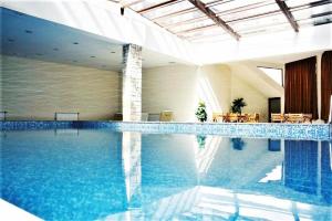 a large swimming pool in a building with blue water at Predela 1 in Bansko