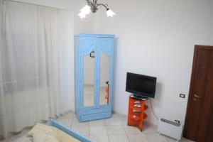 un armario azul en una habitación con TV en B&B Il Sole, en Torre Annunziata