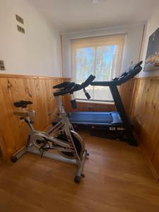 a gym with a bike in a room with a window at Casa Costa Zapallar in Catapilco