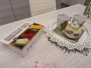 un tavolo con due tazze da tè e una scatola di Old City Port House a Civitavecchia