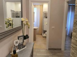 einen Flur mit einem Spiegel und einem Waschbecken im Bad in der Unterkunft Old City Port House in Civitavecchia