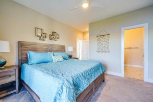 een slaapkamer met een bed met een blauw dekbed bij Lakefront Carolina Beach Townhome with 3 Balconies! in Carolina Beach