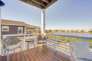 een balkon met 2 stoelen en een tafel en uitzicht op het water bij Lakefront Carolina Beach Townhome with 3 Balconies! in Carolina Beach